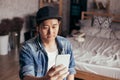 Young Asian man expressing serious look while talking video call via smartphone wearing headphones at home. Royalty Free Stock Photo