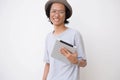 Young asian man with fedora hat and glasses using tablet and smiling at camera while holding computer tablet pc Royalty Free Stock Photo