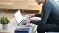 Young asian man freelancer working online with computer laptop while sitting on sofa at home. Royalty Free Stock Photo