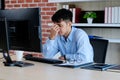 Young asian man with frustrated expression while working with computer at office desk, office lifestyle