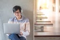 Young Asian student man using laptop in college Royalty Free Stock Photo