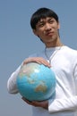 Young Asian Man with a Globe Royalty Free Stock Photo