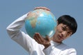 Young Asian Man with a Globe Royalty Free Stock Photo
