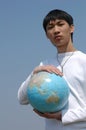 Young Asian Man with a Globe Royalty Free Stock Photo