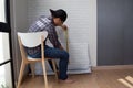 Young Asian man glueing wallpapers on the wall at home.