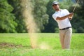 Young Asian man golfer hitting a bunker shot Royalty Free Stock Photo