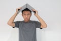 Young Asian man in grey t-shirt Feeling stress and confuse with laptop in his head. Frustrated and stressed young man with work Royalty Free Stock Photo