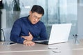 A young Asian man has a heart attack, stroke, panic attack, pneumonia at the workplace Royalty Free Stock Photo