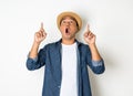 Young asian man with hat feels shock and surprise with overly face expression and looking on blank space Royalty Free Stock Photo