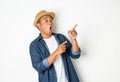Young asian man with hat feels shock and surprise with overly face expression and looking on blank space Royalty Free Stock Photo