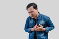 Young Asian man having chest pain or heart trouble and pressing his chest Royalty Free Stock Photo