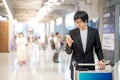 Young asian man using smartphone in airport terminal Royalty Free Stock Photo