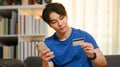 Young asian man holding credit card, paying bill with online payment via internet on smart phone Royalty Free Stock Photo