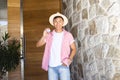 Young Asian man holding a vote badge stands by a stone wall, with copy space Royalty Free Stock Photo