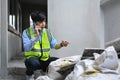 Young asian man inspectors talking on mobile phone and checking building material at construction site