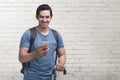 Young asian man journey with mobile phone carrying suitcase Royalty Free Stock Photo