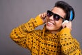 Young Asian man listening to music against gray background Royalty Free Stock Photo