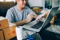 Young asian man looking on computer laptop and writing order list on paper, SME concept Royalty Free Stock Photo