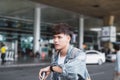 Young asian man looking at his watch in front at the airport terminal Royalty Free Stock Photo