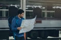 Young asian man looking on map in train station. Royalty Free Stock Photo