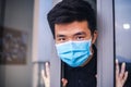 Young asian man with medical mask opens the house door. concept.