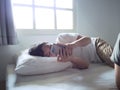 Young Asian man with mobile smart phone lying down on the bed Royalty Free Stock Photo