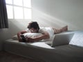 Young Asian man with mobile smart phone lying down on the bed in morning Royalty Free Stock Photo