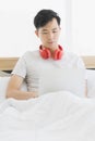 Asian man wearing red headphone, listening music Royalty Free Stock Photo