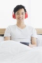 Asian man wearing red headphone, listening music Royalty Free Stock Photo