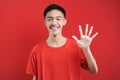 Young Asian man with number five sign finger gesture Royalty Free Stock Photo