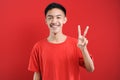 Young Asian man with number two sign finger gesture Royalty Free Stock Photo