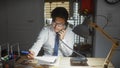 A young asian man in an office setting talking on the phone while working Royalty Free Stock Photo