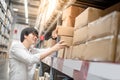 Young Asian man picking paper boxes in warehouse Royalty Free Stock Photo