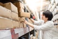 Young Asian man picking paper boxes in warehouse Royalty Free Stock Photo