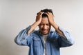 Young Asian man put hands to his head. He feeling sick and headache due to having some problems. His stress make him uncomfortable Royalty Free Stock Photo