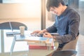 Young Asian man reading book in workspace Royalty Free Stock Photo
