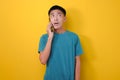 Young Asian man with shock face got a call from stranger or cheater