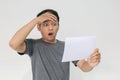 Young Asian man is shocked and surprised with the white mail message or the bill