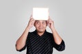 Young Asian Man Showing Small Whiteboard Covering His Head Royalty Free Stock Photo