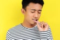 Young Asian man showing ulcer or blister in his mouth at camera, isolated on yellow Royalty Free Stock Photo