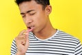 Young Asian man showing ulcer or blister in his mouth at camera, isolated on yellow Royalty Free Stock Photo