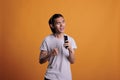 Young asian man singing karaoke, using smartphone as microphone Royalty Free Stock Photo
