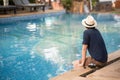 Young Asian man sitting on the edge of swimming pool Royalty Free Stock Photo