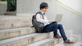 Asian man university student using laptop on stair Royalty Free Stock Photo