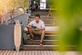 Young Asian man sitting on stairs outside using a tablet Royalty Free Stock Photo