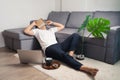Young Asian man sleeping and laying on floor after hard working and video conferencing. Work from home concept