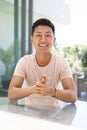 A young Asian man smiles brightly at the camera on a video call Royalty Free Stock Photo