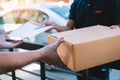 Young asian man smiling while delivering a cardboard box to the woman holding document to signing signature Royalty Free Stock Photo