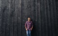 Young Asian man smiling while leaning against a wall outside Royalty Free Stock Photo