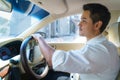 Young Asian man smiling and looking at the urban road while driving a car in city Royalty Free Stock Photo